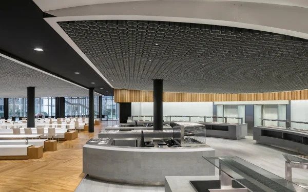 Office headquarters cafeteria designed with Laminam Pietra di Savoia Grigia Italian porcelain; grey surfaces providing a durable and stylish setting for communal spaces.