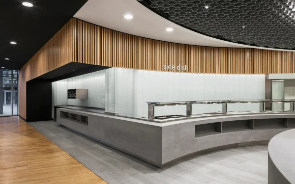 Office headquarters cafeteria designed with Laminam Pietra di Savoia Grigia Italian porcelain; grey surfaces providing a durable and stylish setting for communal spaces.