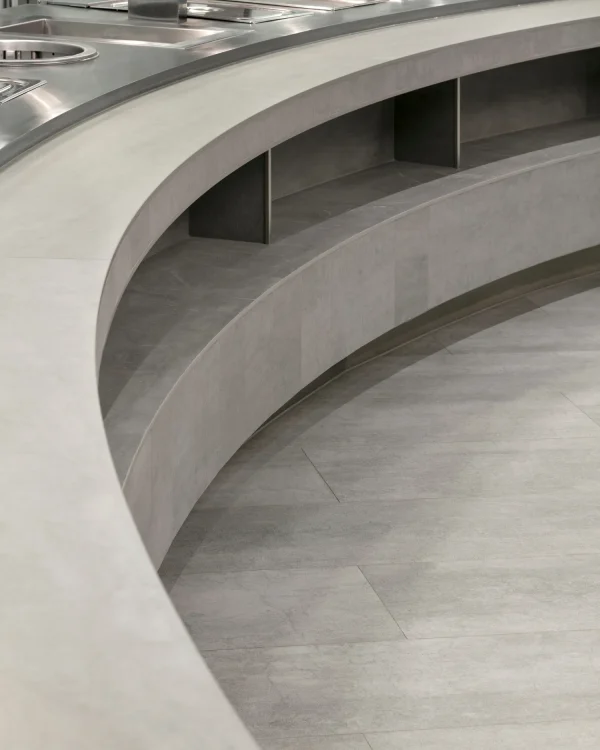 University staircase, wall cladding, and flooring featuring Laminam Pietra di Savoia Grigia porcelain; sleek grey surfaces with a structured Bocciardato finish, offering durability and modern elegance.