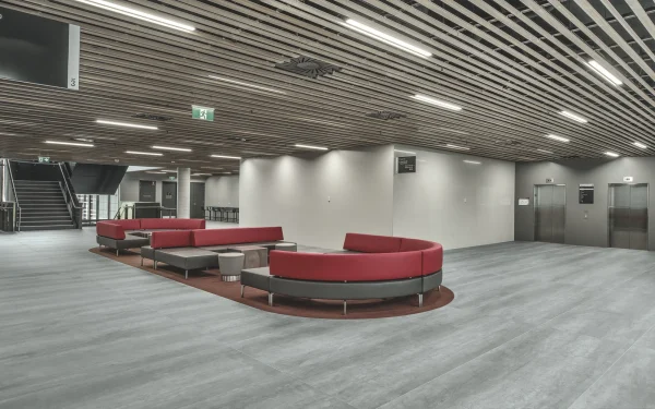University staircase, wall cladding, and flooring featuring Laminam Pietra di Savoia Grigia porcelain; sleek grey surfaces with a structured Bocciardato finish, offering durability and modern elegance.