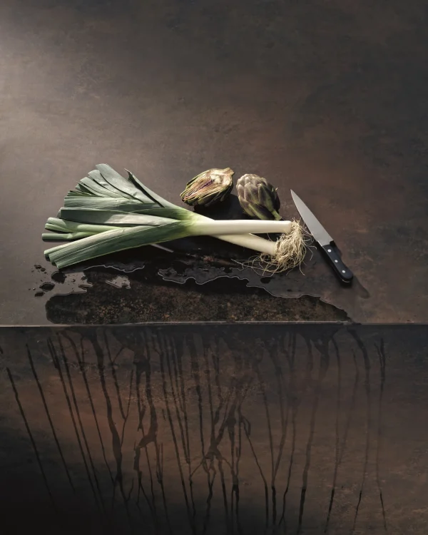 Still life image of Laminam Ossido Bruno Italian porcelain; textured brown surface with metallic undertones highlighting its industrial charm.