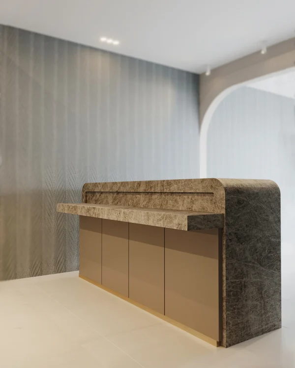 Leathered 2 cm Naica quartzite slab in gray and brown tones; showcased in a luxury showroom.